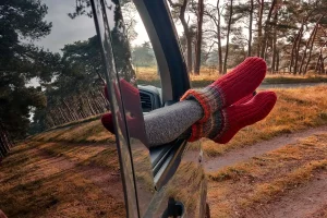Pies por la ventana mostrando como dormir en una furgoneta sin camperizar
